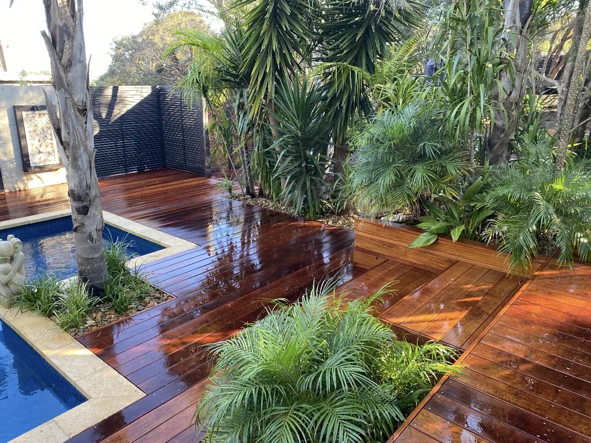 Timber deck around a pool in a tropical garden